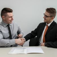 Two men shaking hands at a meeting